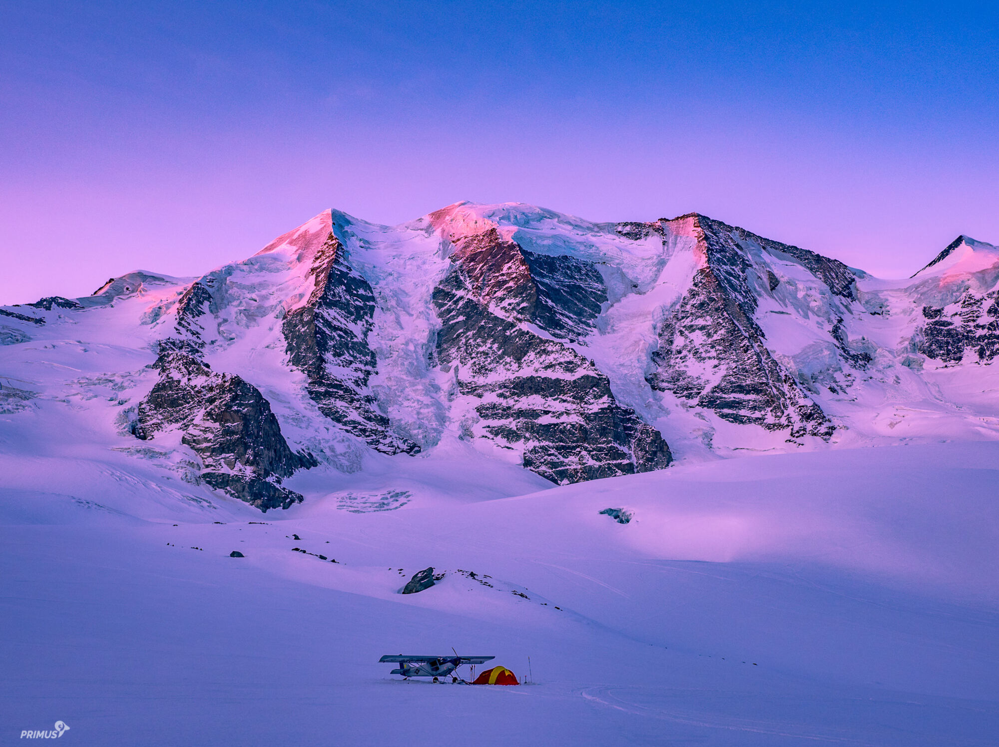 Leichtflugzeug und Zelt auf einem Gletscher im Abendlicht