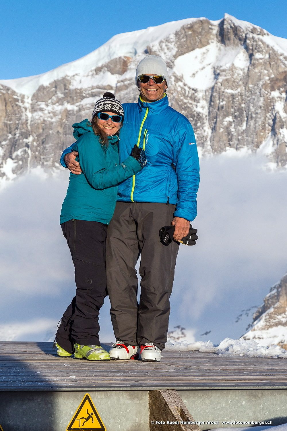 Roland und Claudia Arm in Arm vor verschneiten Bergen