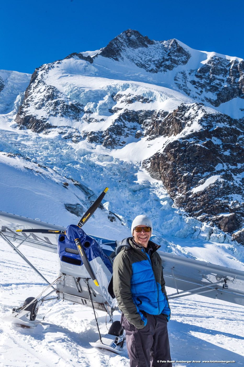Person neben einem Leichtflugzeug im Schnee