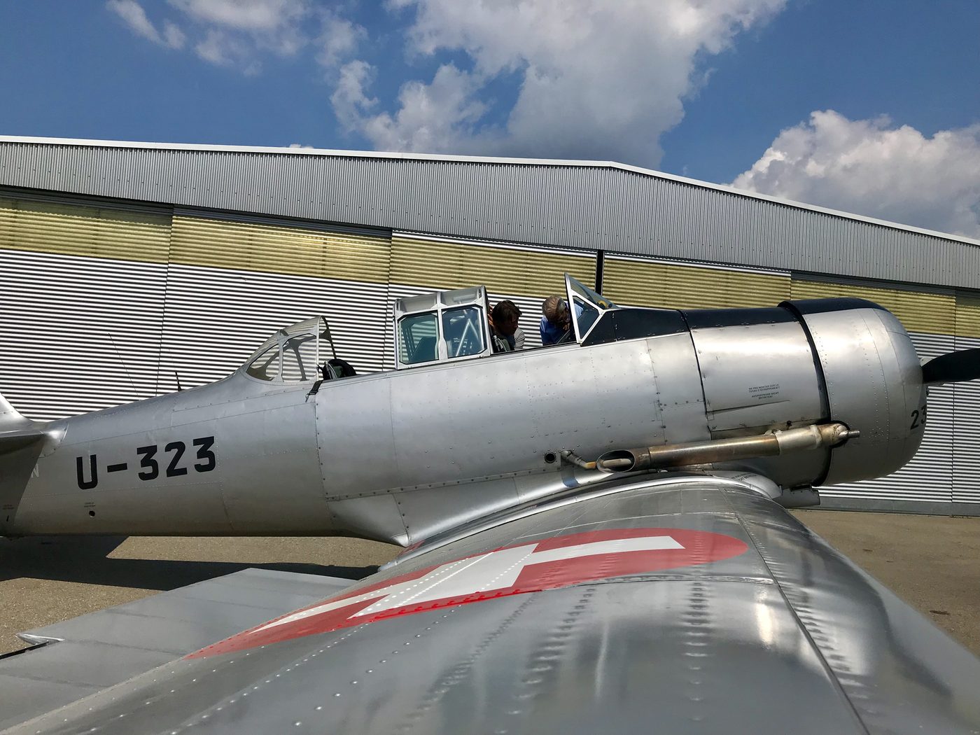 Silberne AT-6 mit Schweizer Kreuz vor einem Hangar
